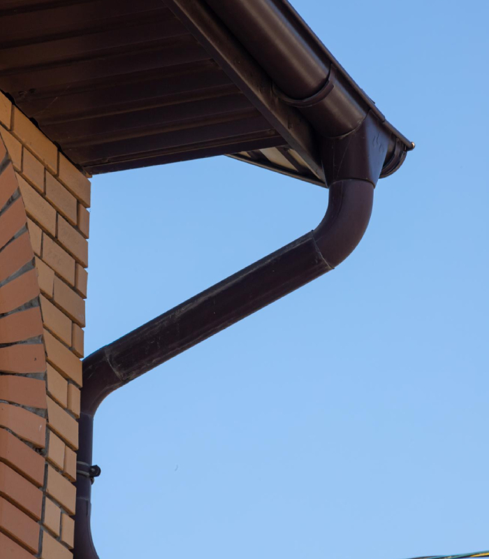 Gouttière marron installée sur une maison en briques